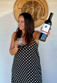 Angie holding a bottle of wine